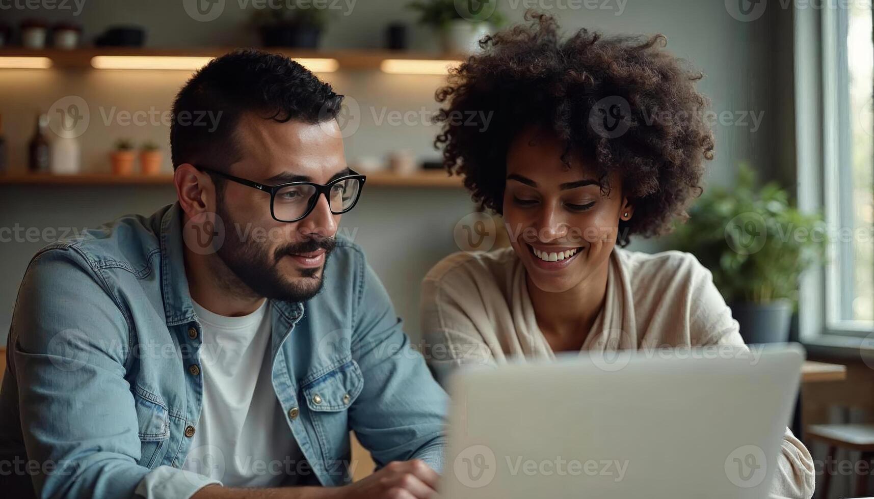 A man and woman are looking at a laptop photo