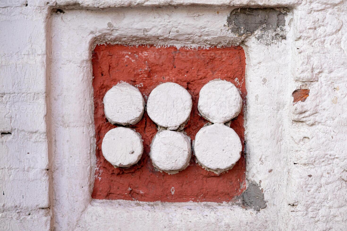 Wall Decoration Featuring Six White Circles on a Red Brick Background photo