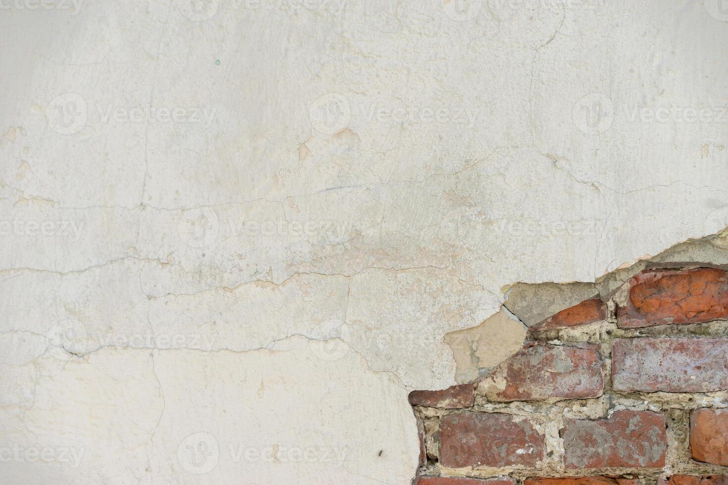 Aged Wall With Exposed Red Bricks and Cracked Plaster Surface photo