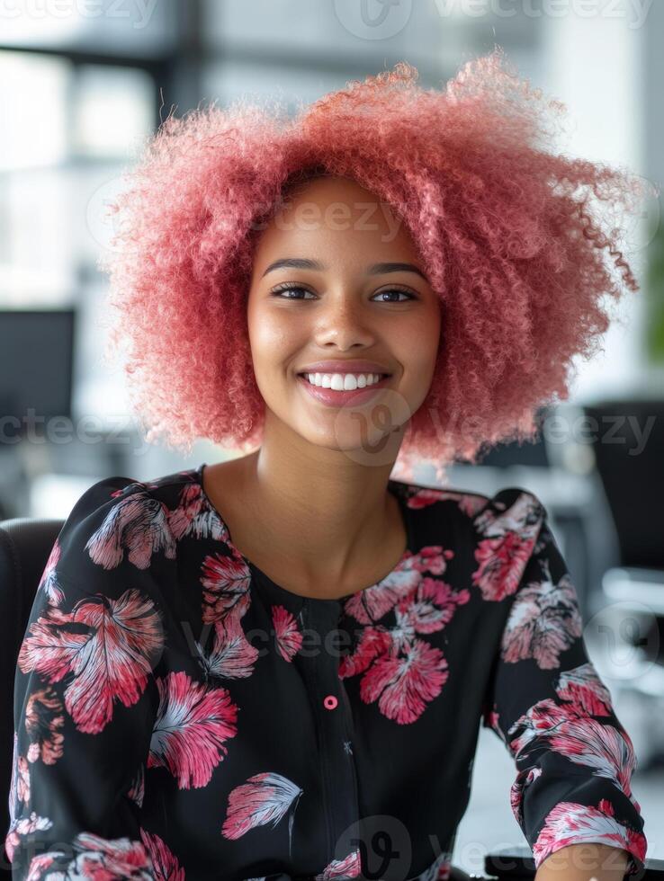 A happy black disabled woman in a wheelchair with pink afro hair radiates positivity in a bright, diverse workplace filled with colleagues photo