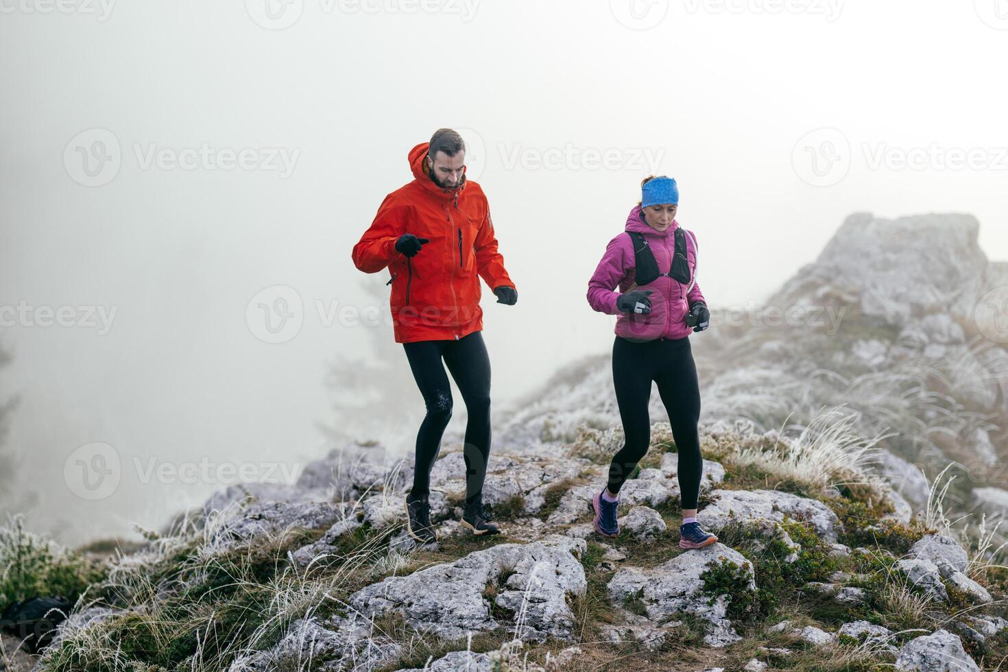 Trail running couple man and woman running on a mountain path photo