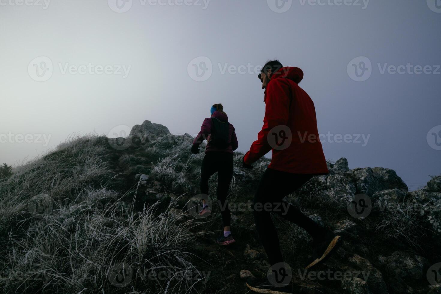 Trail running couple man and woman running on a mountain path photo