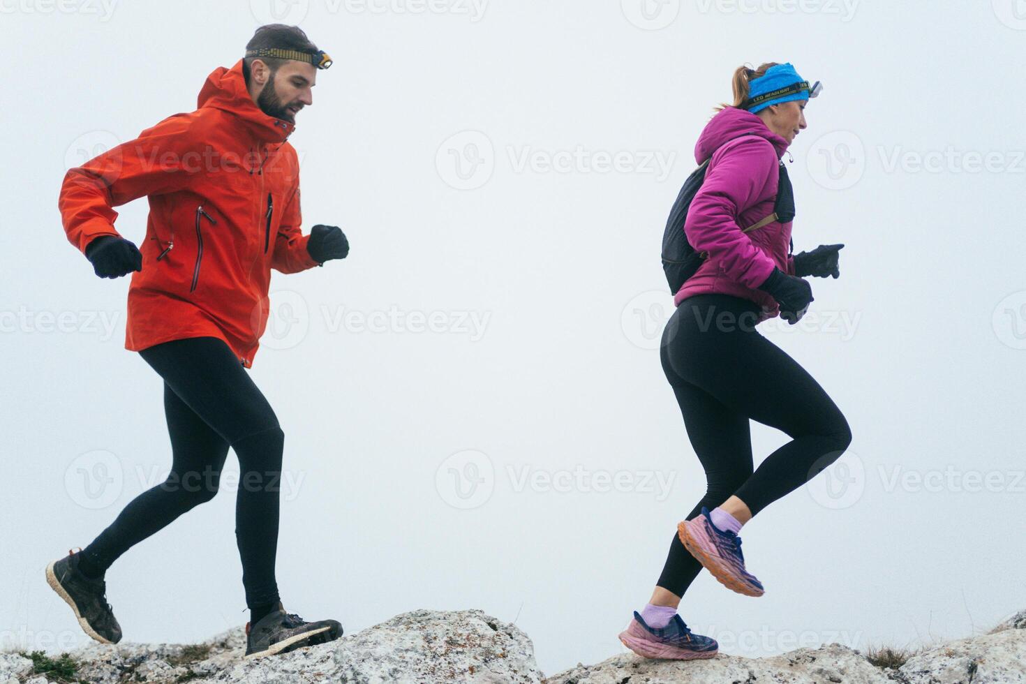 Trail running couple man and woman running on a mountain path photo