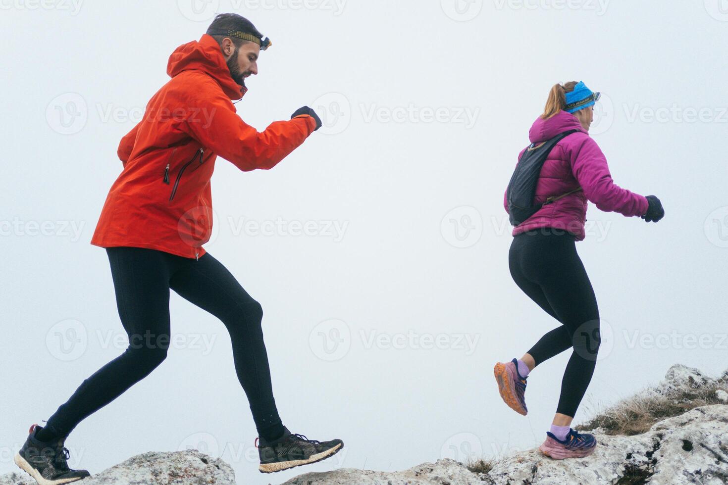 Trail running couple man and woman running on a mountain path photo