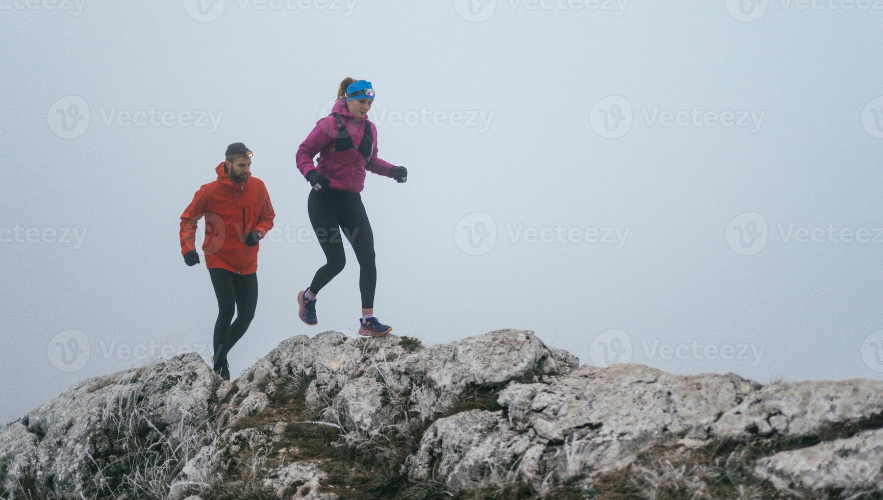 Trail running couple man and woman running on a mountain path photo