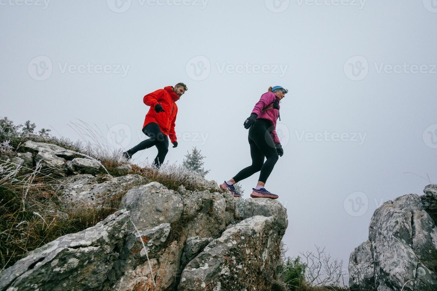 Trail running couple man and woman running on a mountain path photo