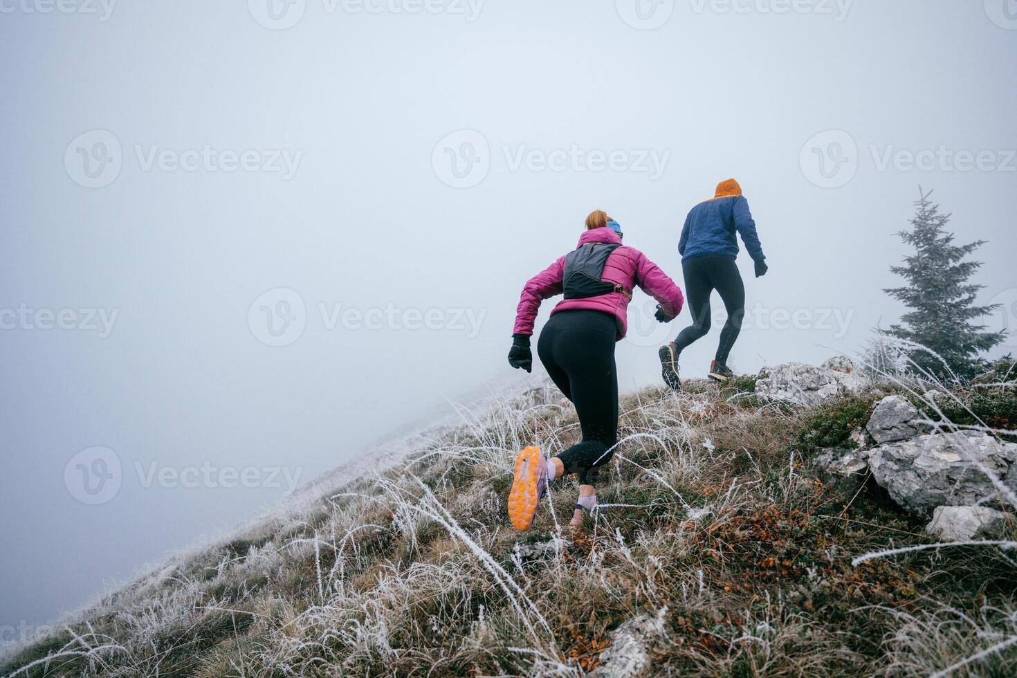 Trail running couple man and woman running on a mountain path photo
