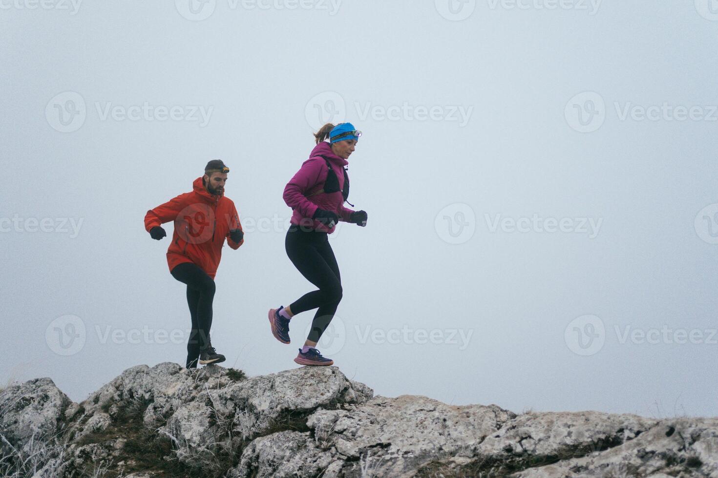 Trail running couple man and woman running on a mountain path photo