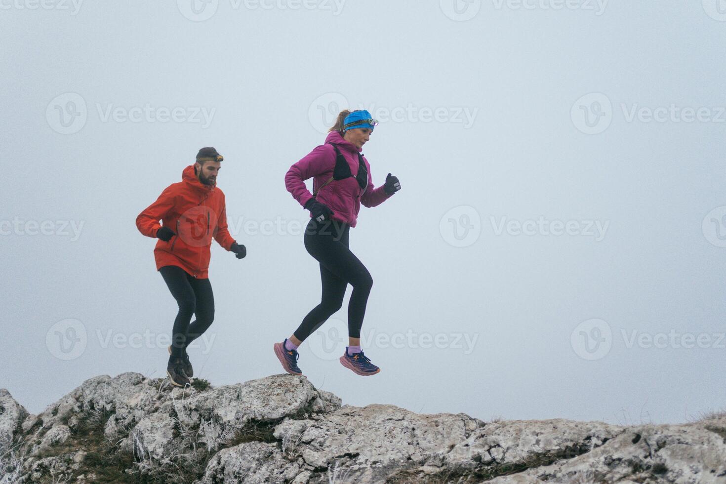 Trail running couple man and woman running on a mountain path photo
