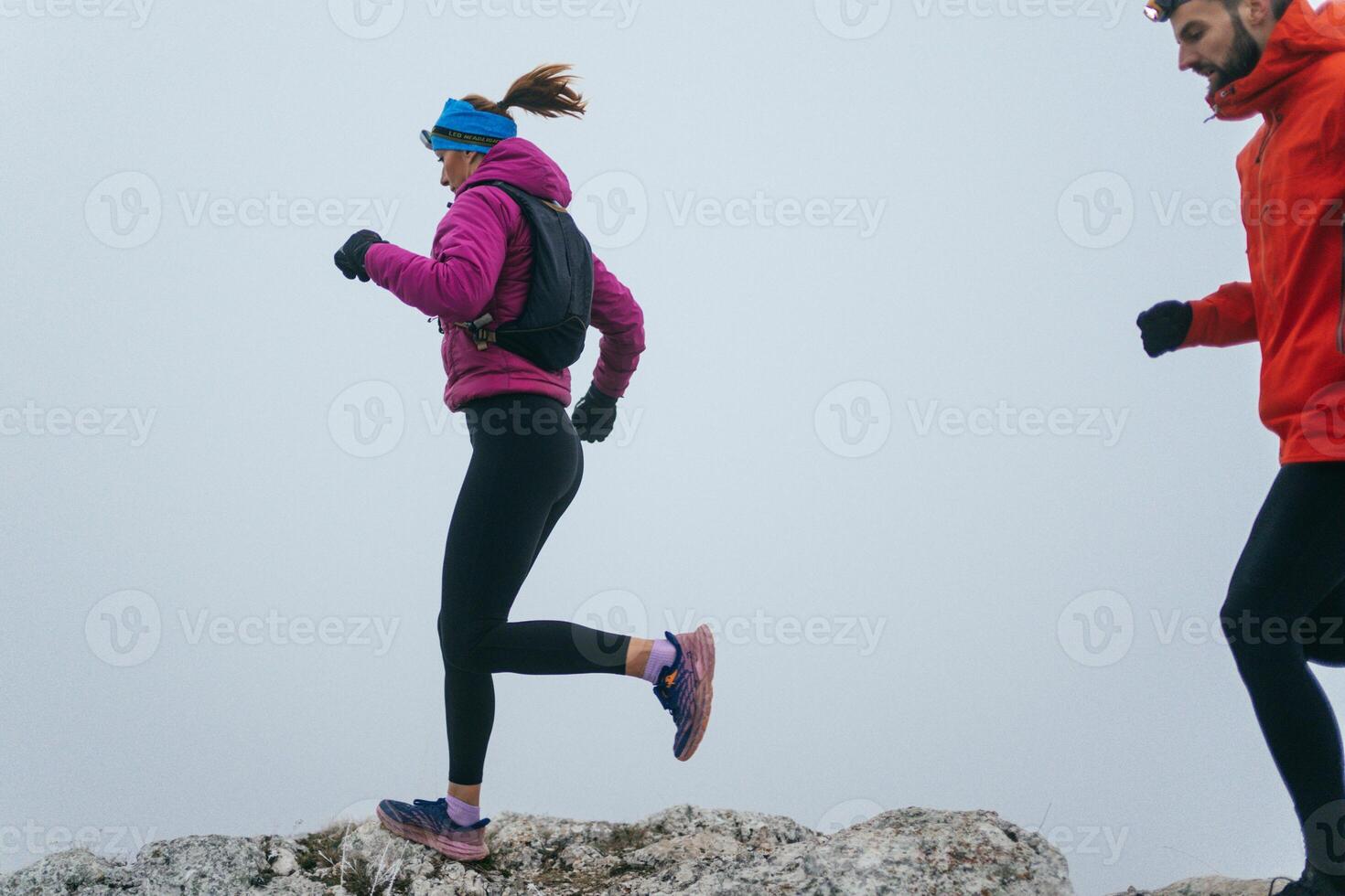Trail running couple man and woman running on a mountain path photo