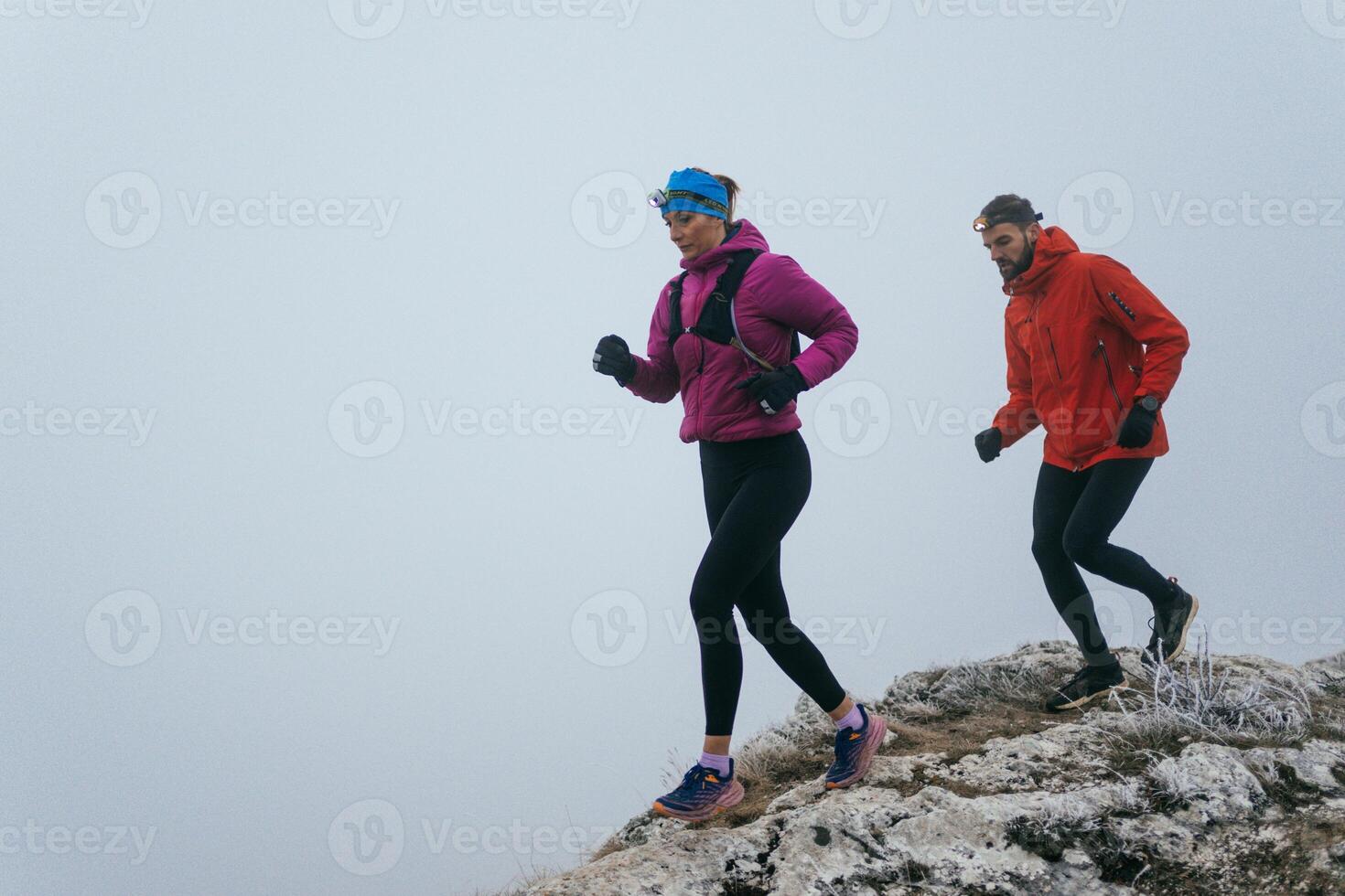 Trail running couple man and woman running on a mountain path photo