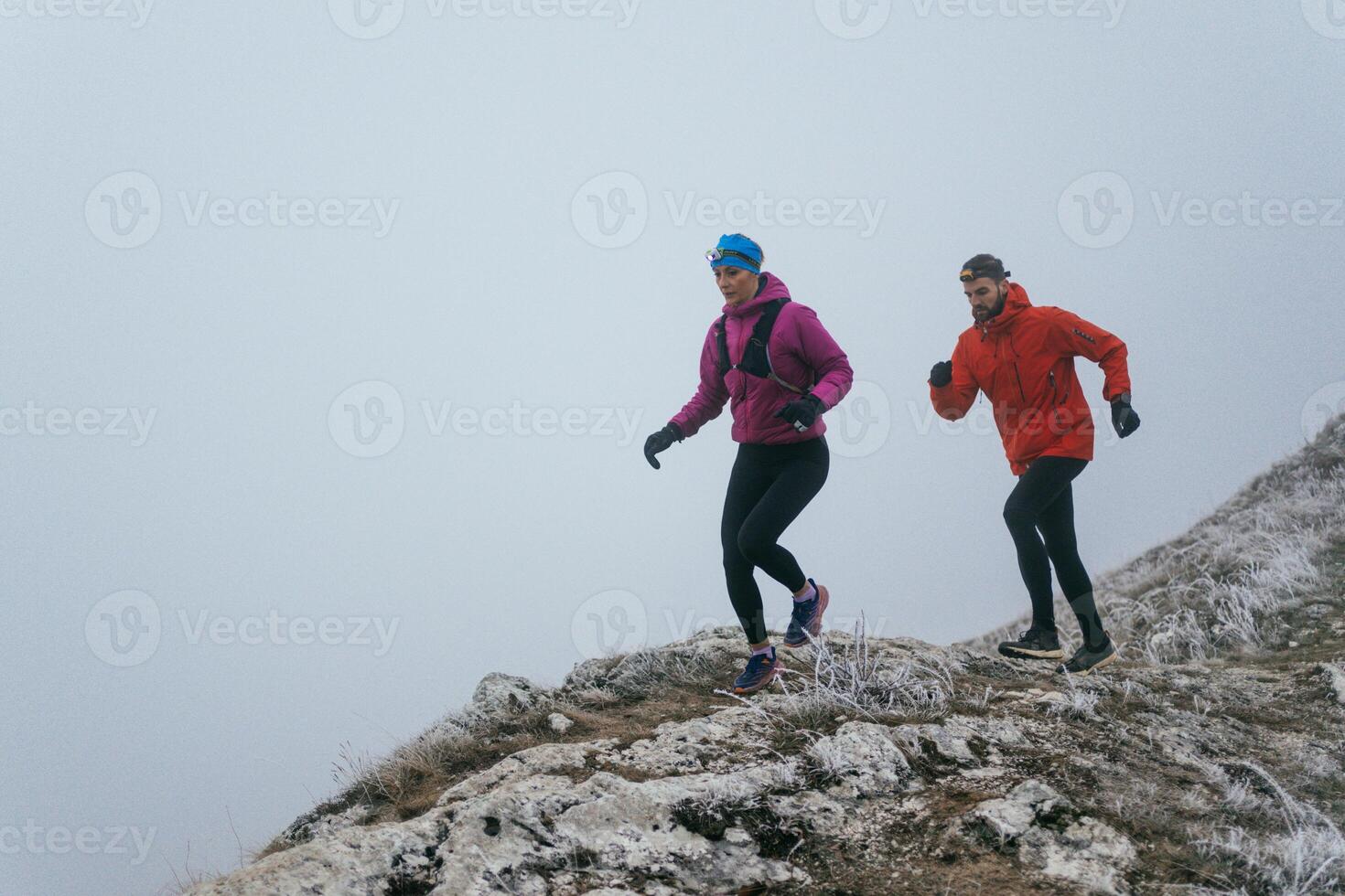 Trail running couple man and woman running on a mountain path photo
