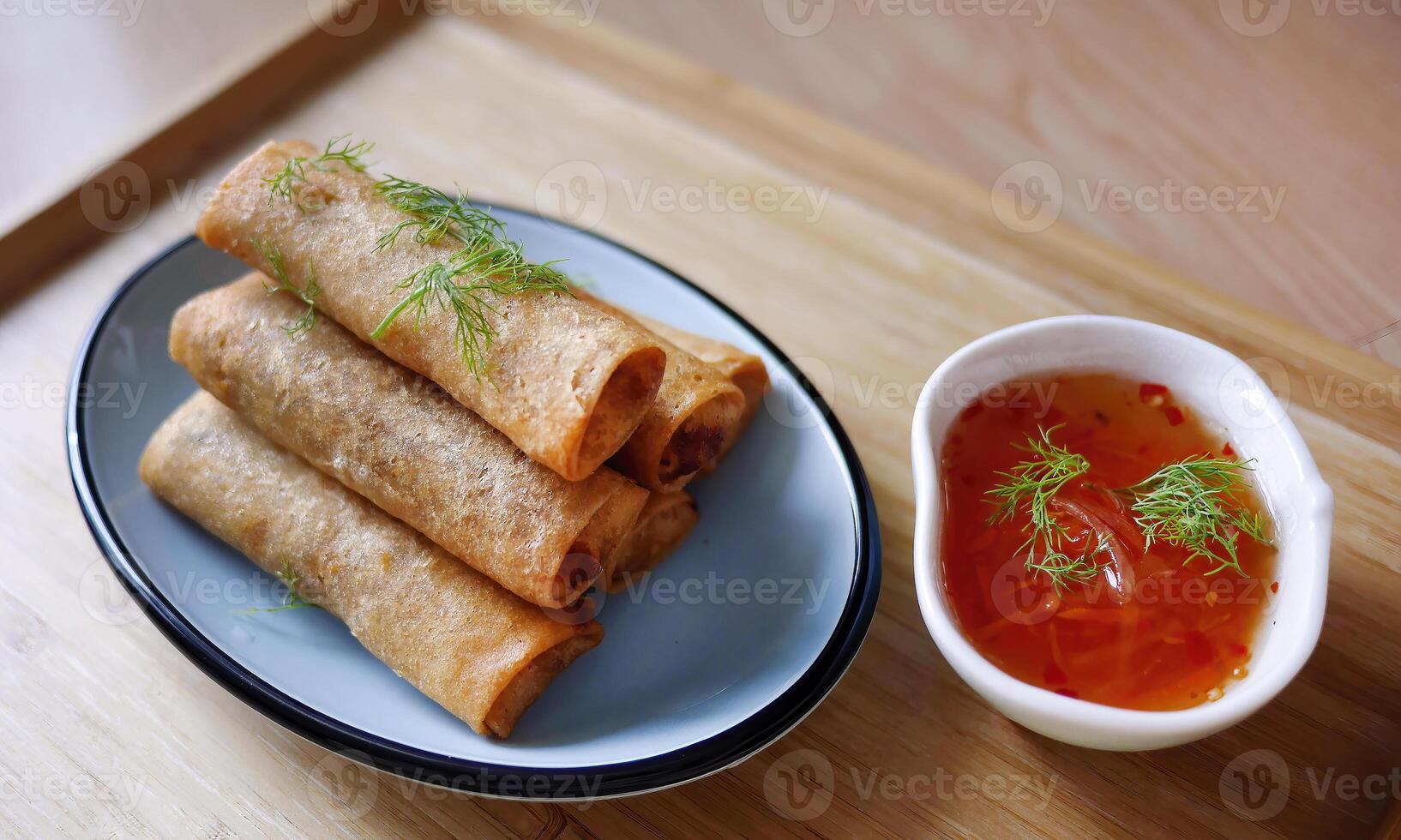 Deep fried spring roll in golden brown color, served in a blue oval shape plate, famous street food in Thailand, food industry concept photo
