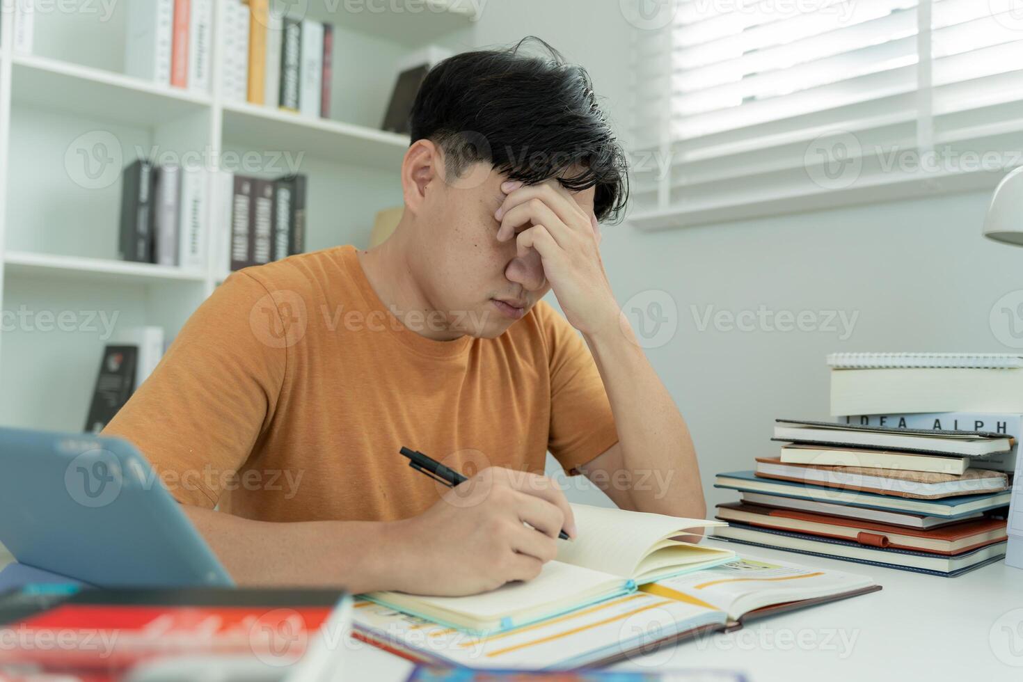 Asian student man have anxiety because of exams, male prepare for test and learning lessons in the library. stress, despair, haste, misunderstanding reading, discouraged, expectation photo