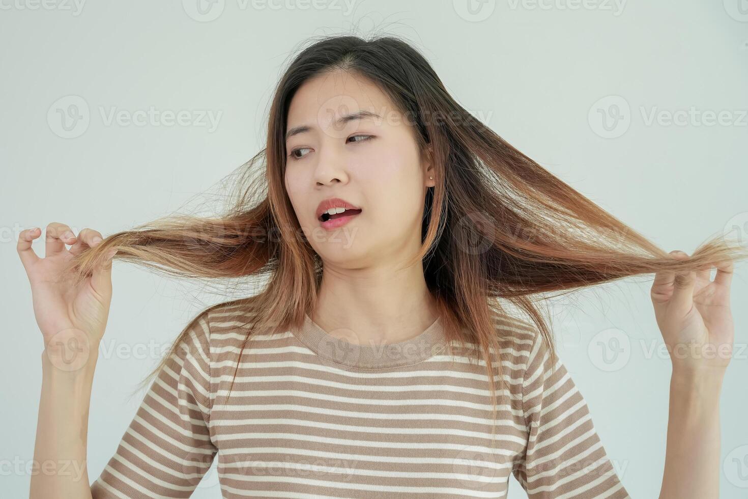 Asian woman very sad and upset looking at damaged hair, hair loss, hair thinning problem, vitamin deficiency, baldness, postpartum, biotin, zinc, menstrual or endocrine disorders photo