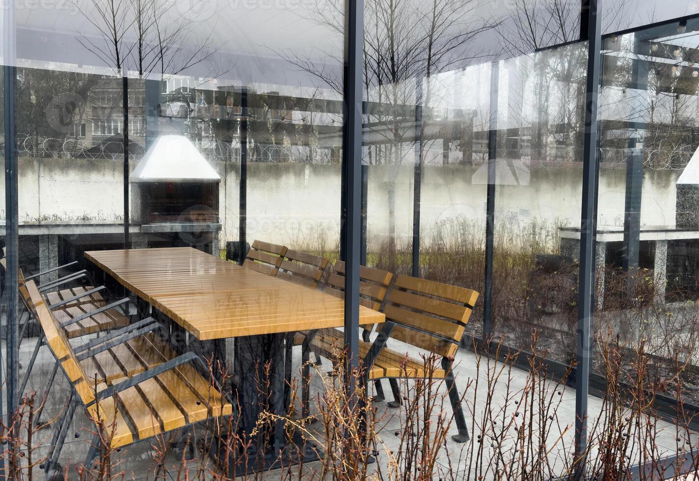 Trendy outdoor patio pergola shade structure, awning and patio roof, dining table, chairs, metal grill surrounded by landscaping photo