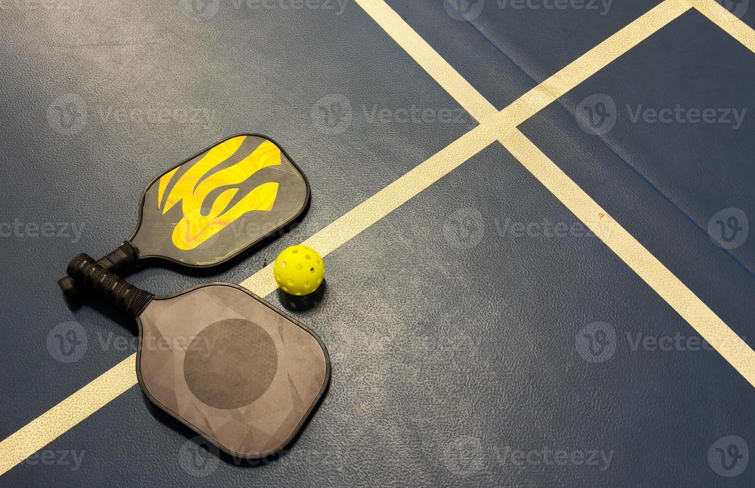 A Pickleball Racquet's on blue court photo