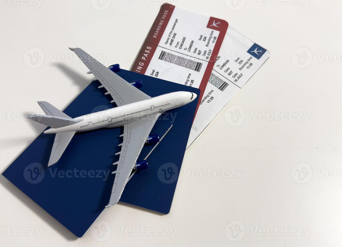 Boarding pass, passport and toy aircraft on desk top view photo