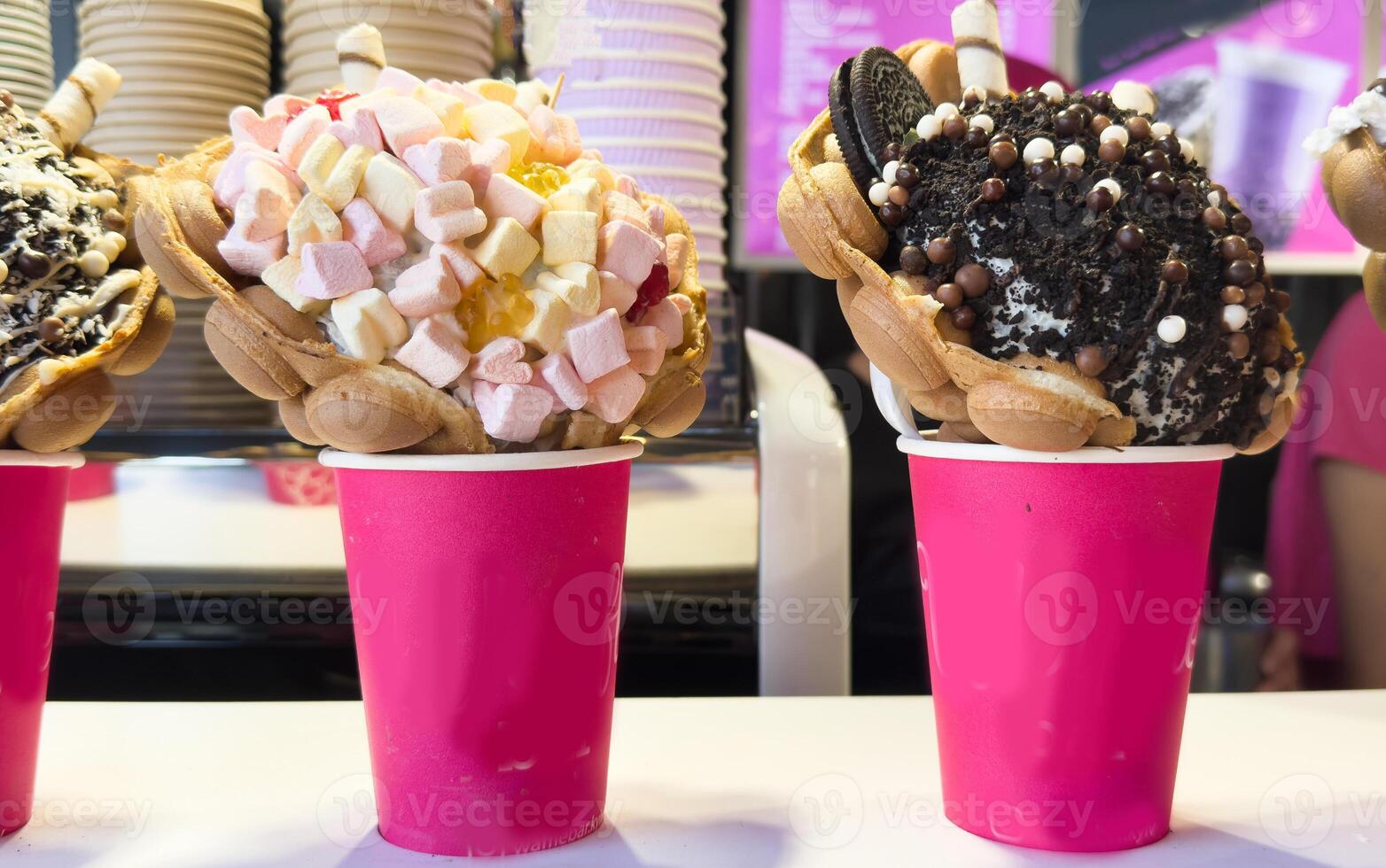 Bubble Waffle cone. Close-up of Assorted Ice Cream Cones with different flavors of ice creams, cookies and sprinkles in a Display in an ice cream Store photo