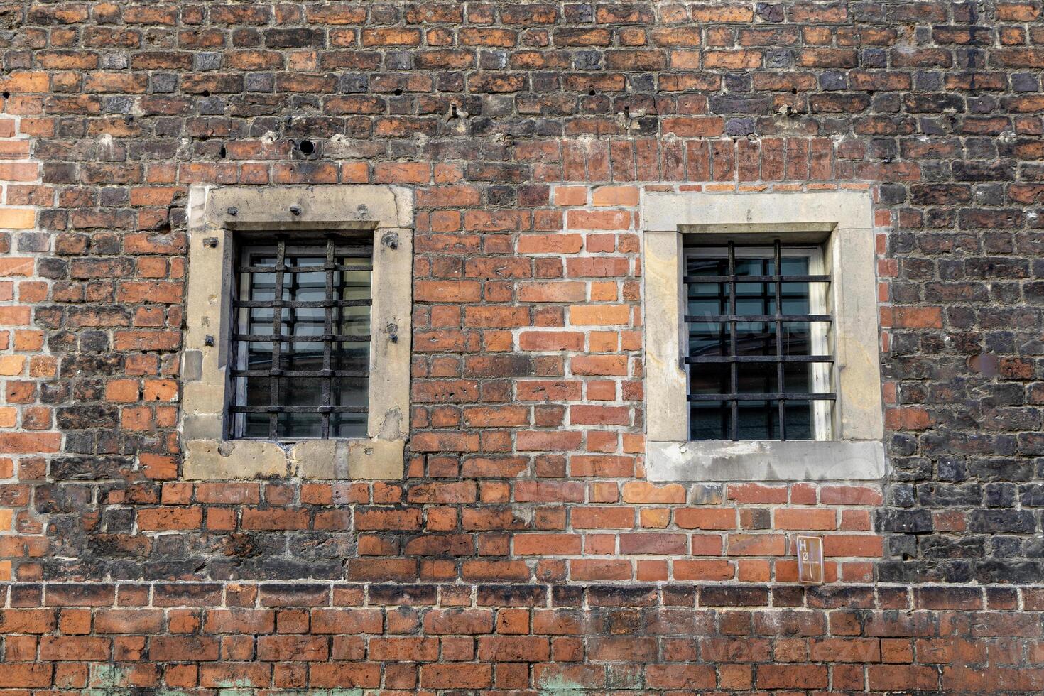 Old brick wall with metal bars on windows. Background. Poland, Wroclaw photo