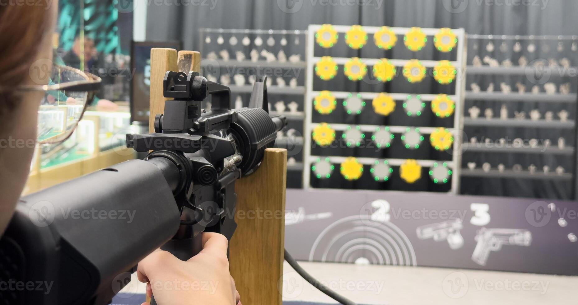Young girl practcing target shooting with a gun photo