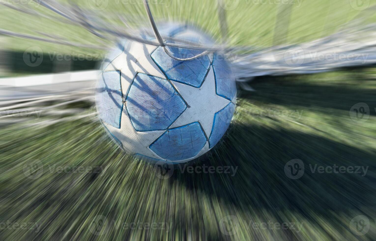 Soccer ball in goal on green background photo