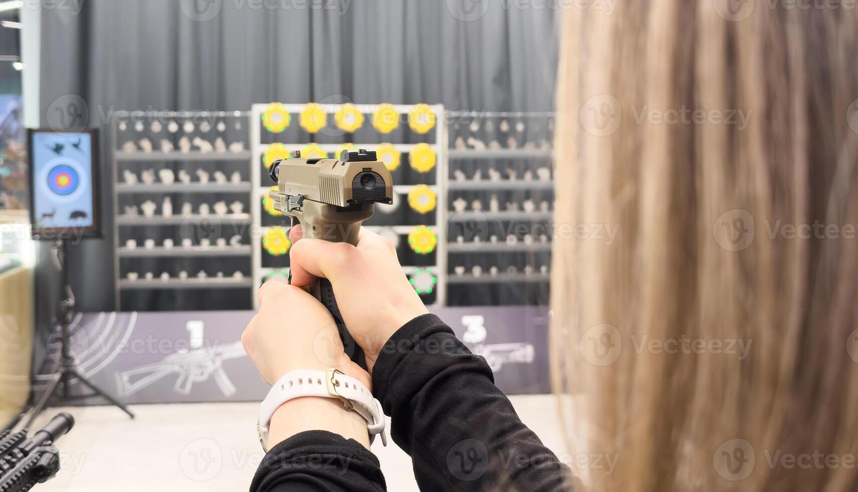 Young girl practcing target shooting with a gun photo