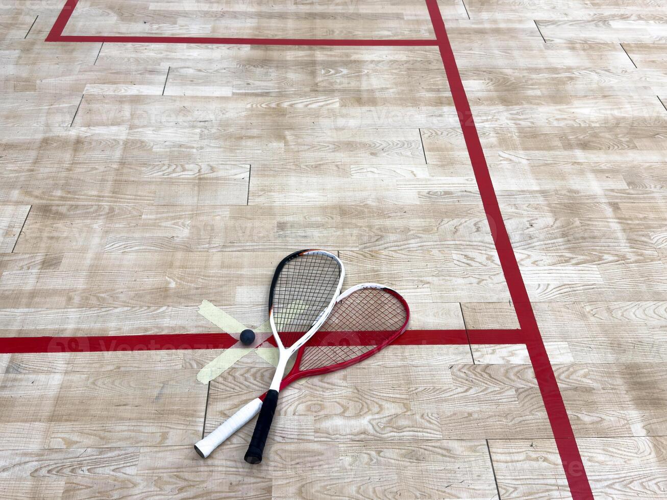 Squash Rackets And a Ball on a Wooden Court Floor. Sport Theme. photo