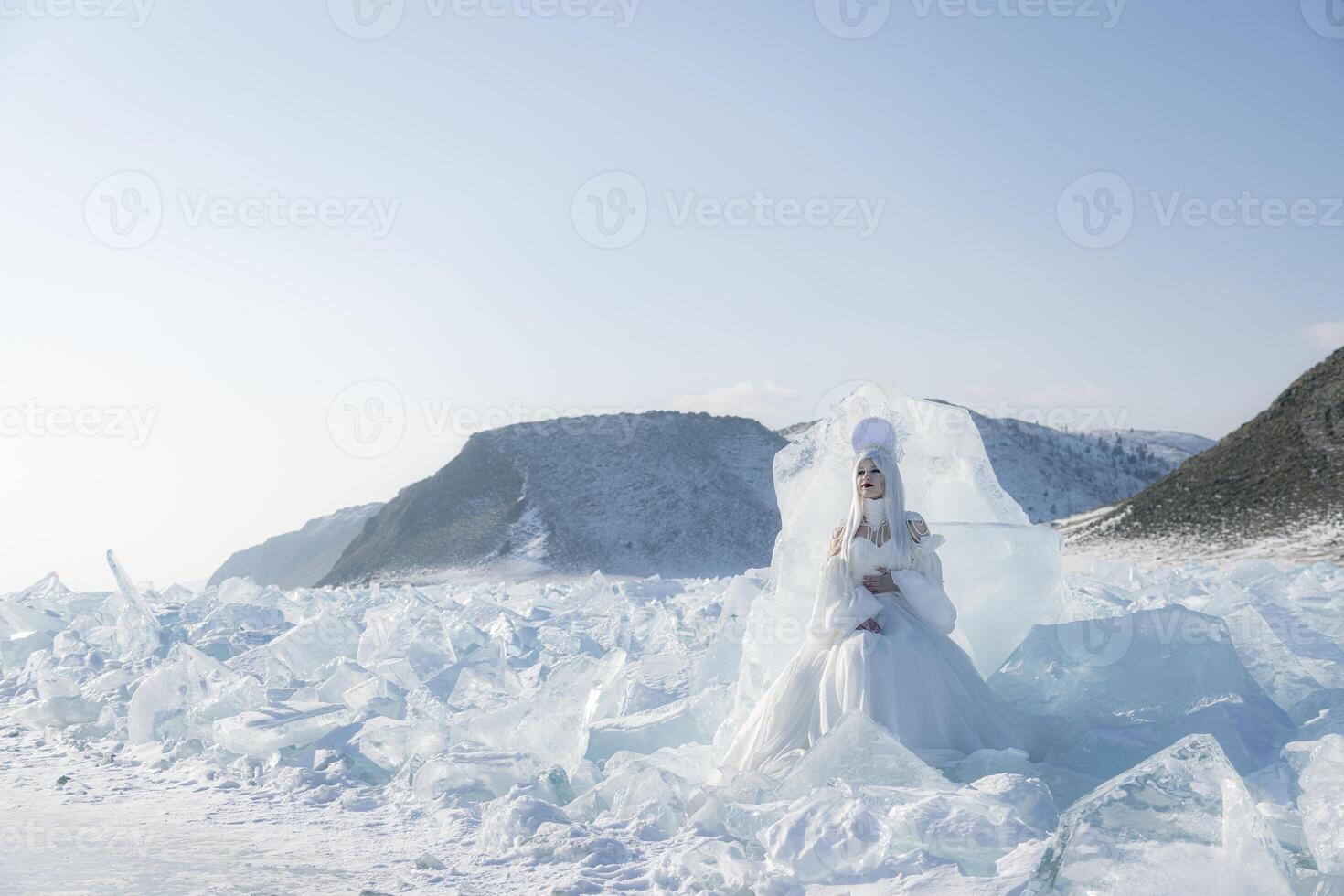 Snow Queen in a white gown among ice shards on Lake Baikal. Magical winter fairytale scene photo