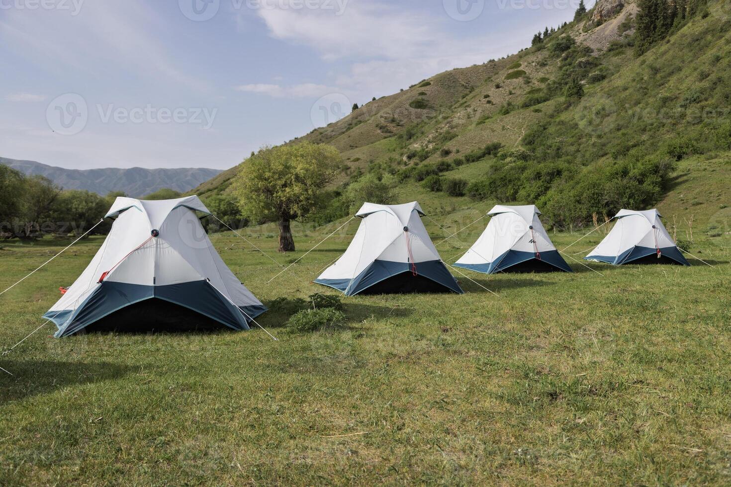 Gray camping tents set in the mountains of Kazakhstan, surrounded by stunning natural landscapes. photo
