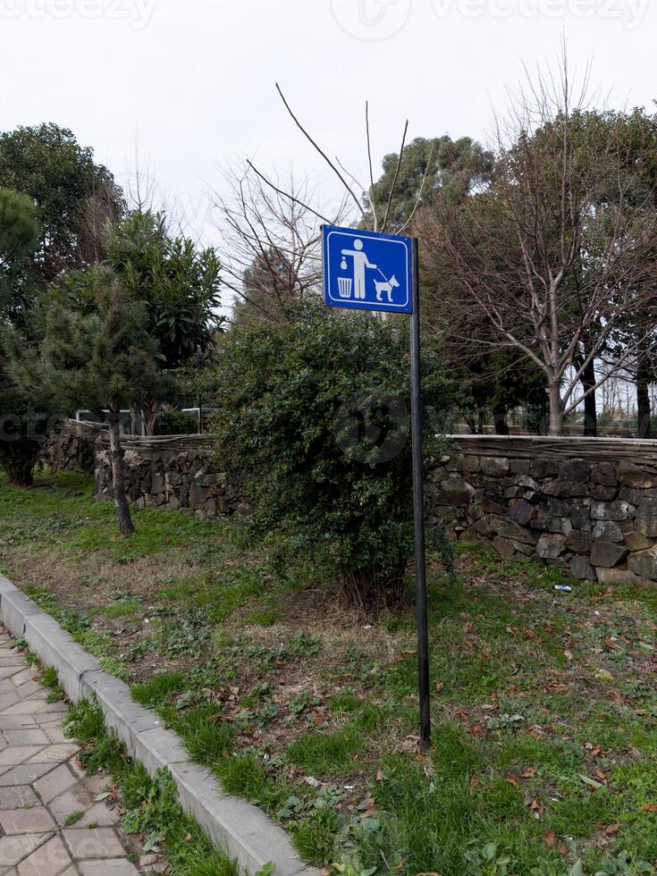 Sign on pole in park to remind you to clean up after your pet photo