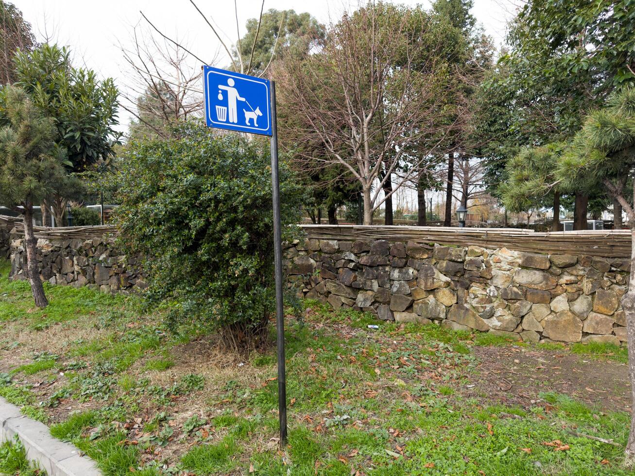 Sign in park illustrating cleaning up dog poop after walking outside photo