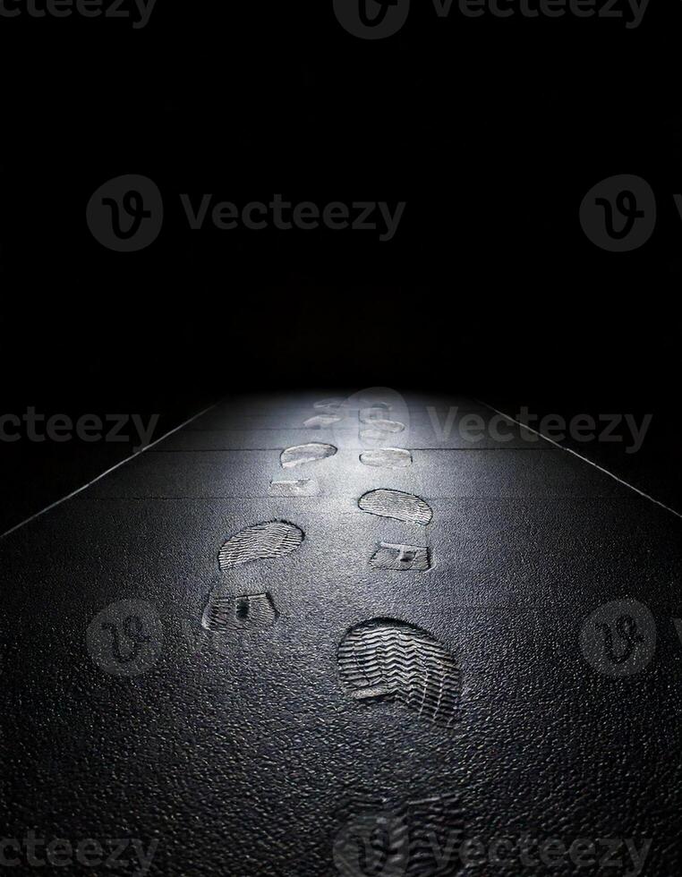 Narrow perscpective with foot steps on the floor fading, black background photo