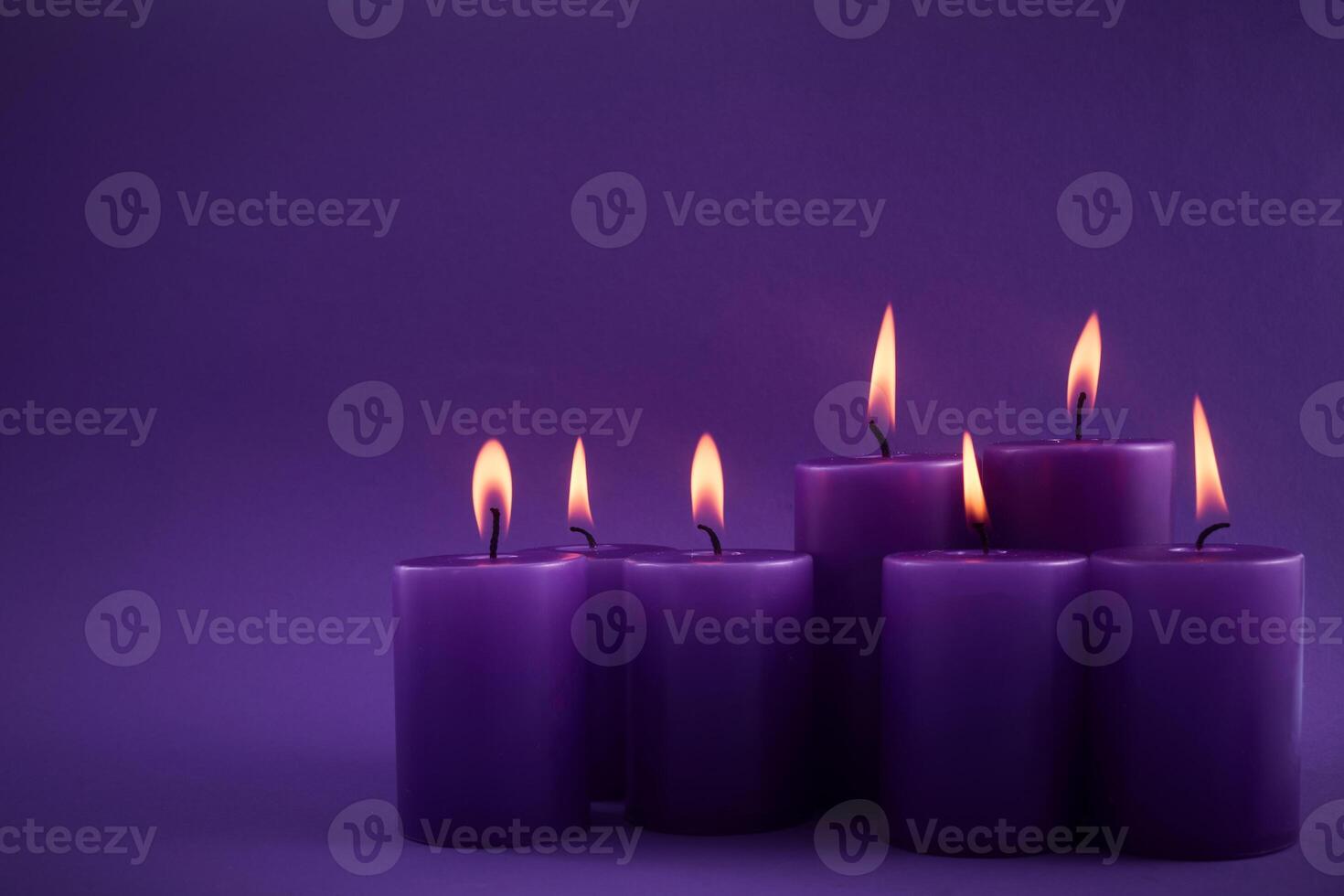 Purple Candle Serenity. A set of seven lit purple candles against a matching background photo