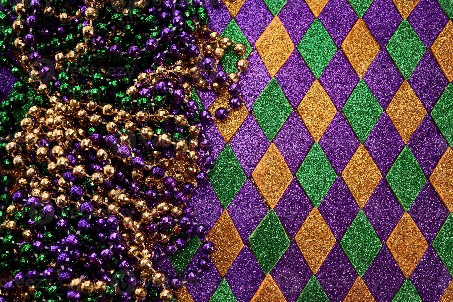 Festive Mardi Gras Beads. Colorful beads and harlequin background photo