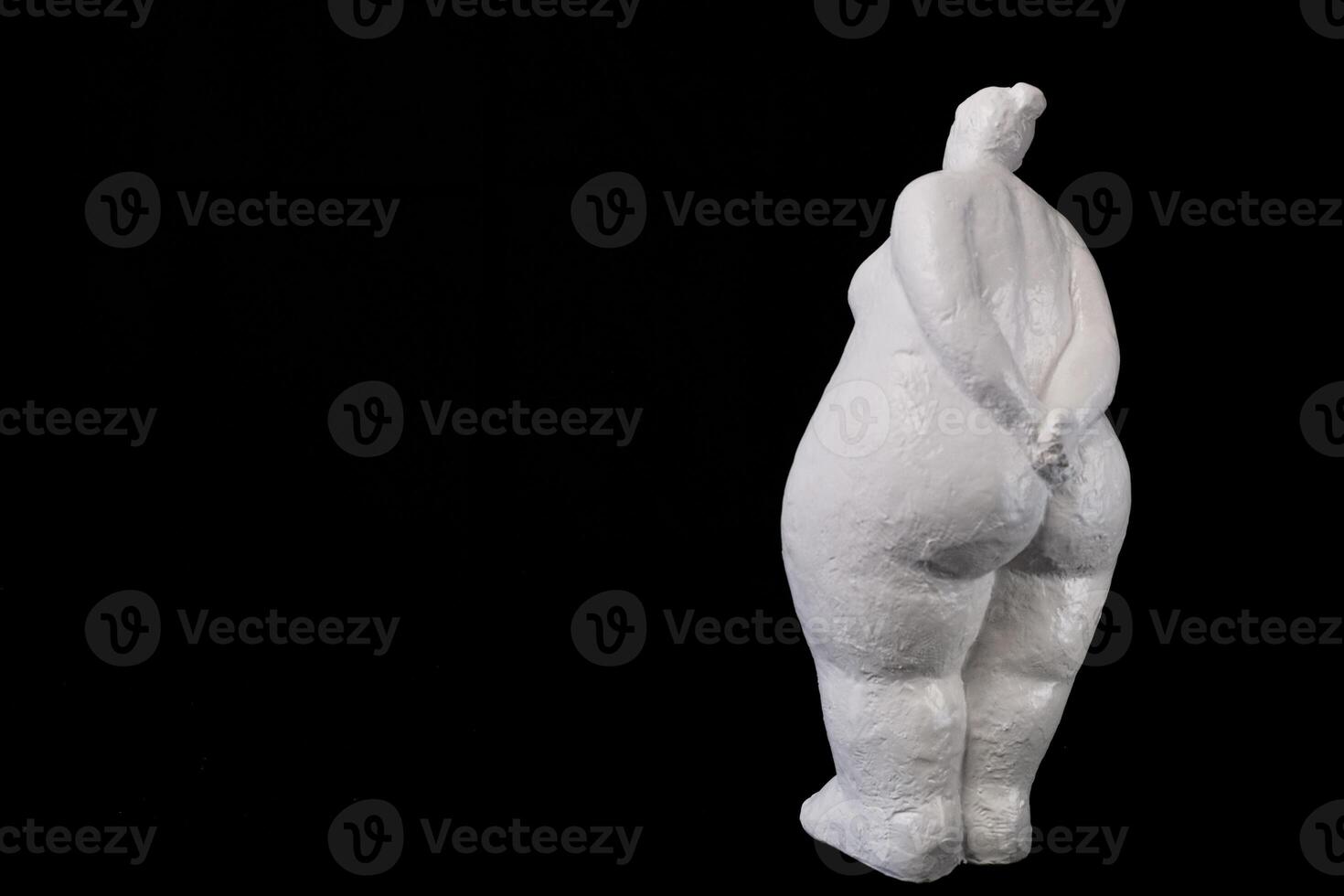 White Plaster Lady Standing Back on Black Solid Background with Copy Space photo