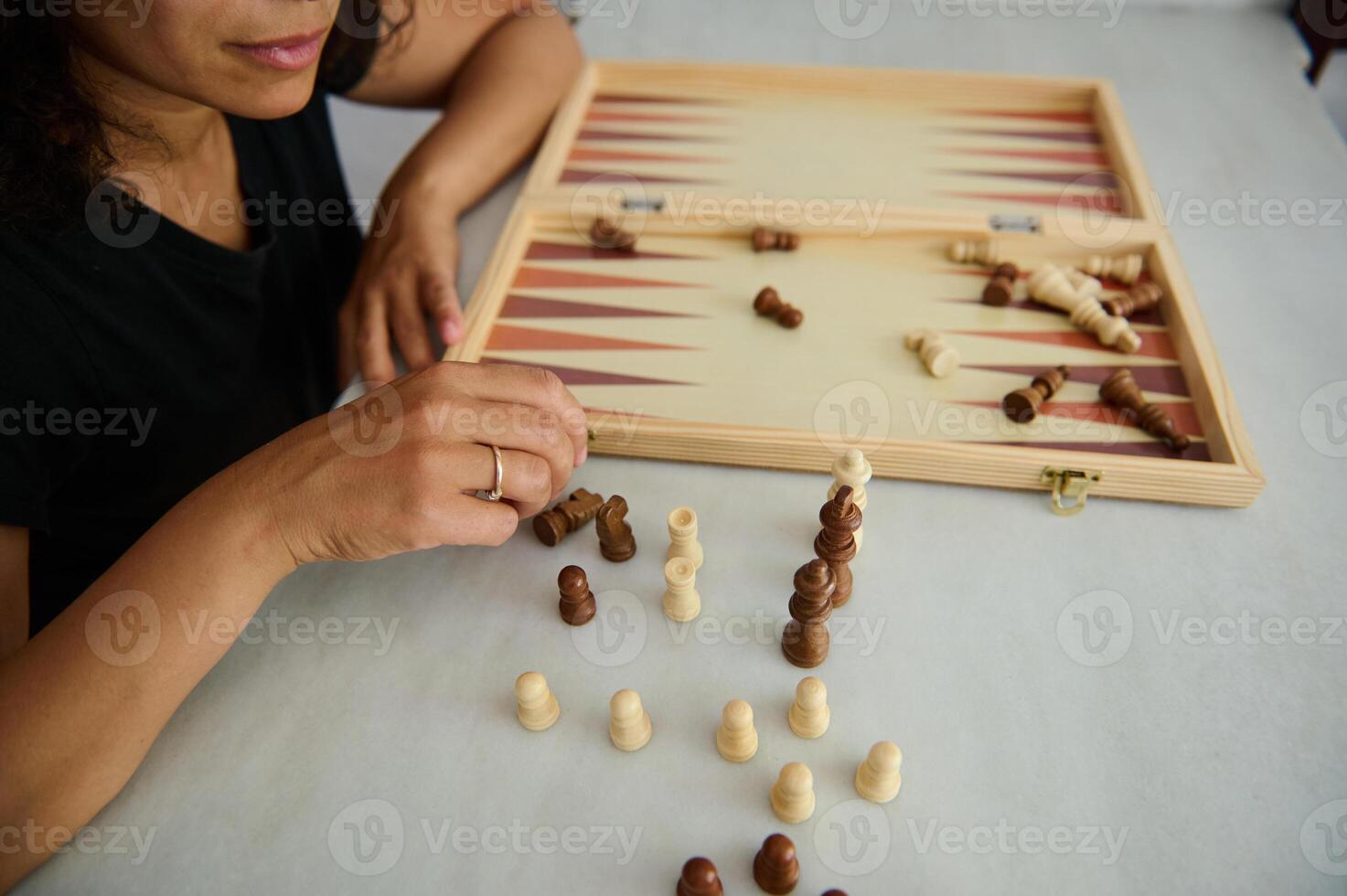 Person playing with wood board pieces at table involving abstract strategy. photo
