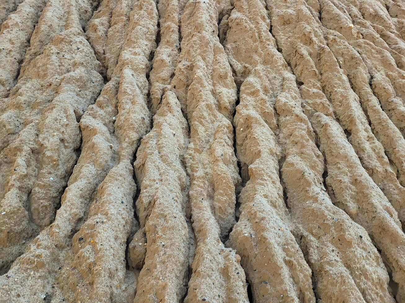 Natural background. A pile of wet sand and traces of streams on it after the rain photo