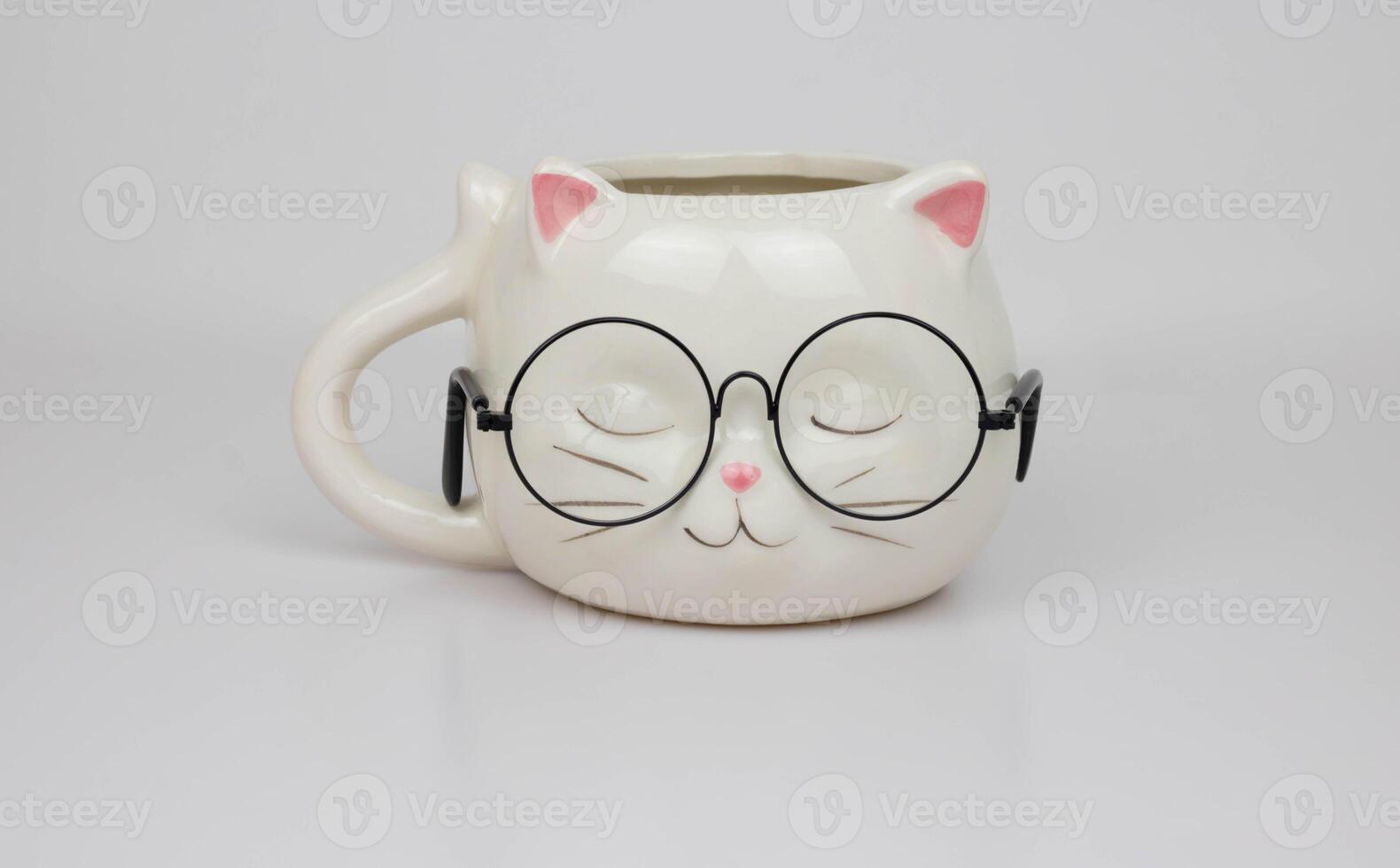 Cute white cup in the shape of a cat's head with round glasses photo