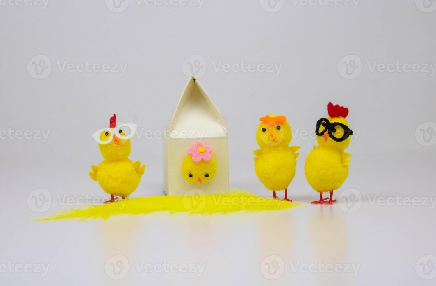 A bird house and four yellow toy chickens stand out against a white background. The concept of Easter photo