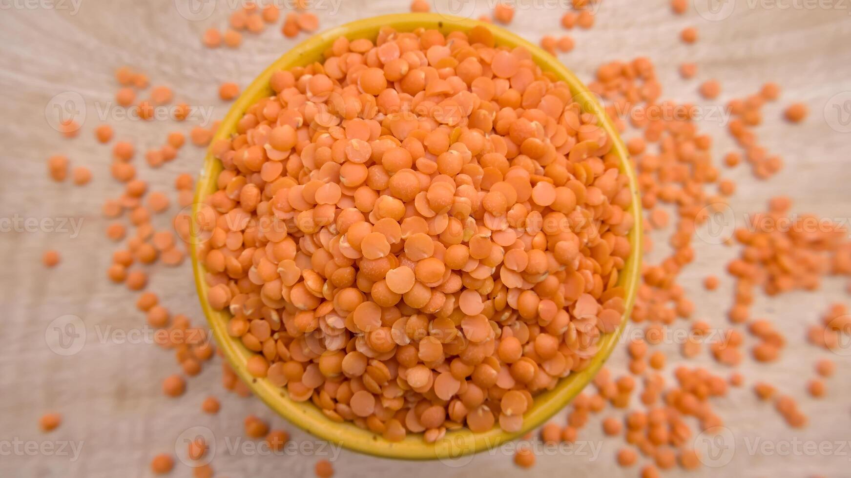 Red Lentils Masoor Dal Split and Dehusked in a Yellow Bowl - Rustic Close-Up Top View Flat Lay photo