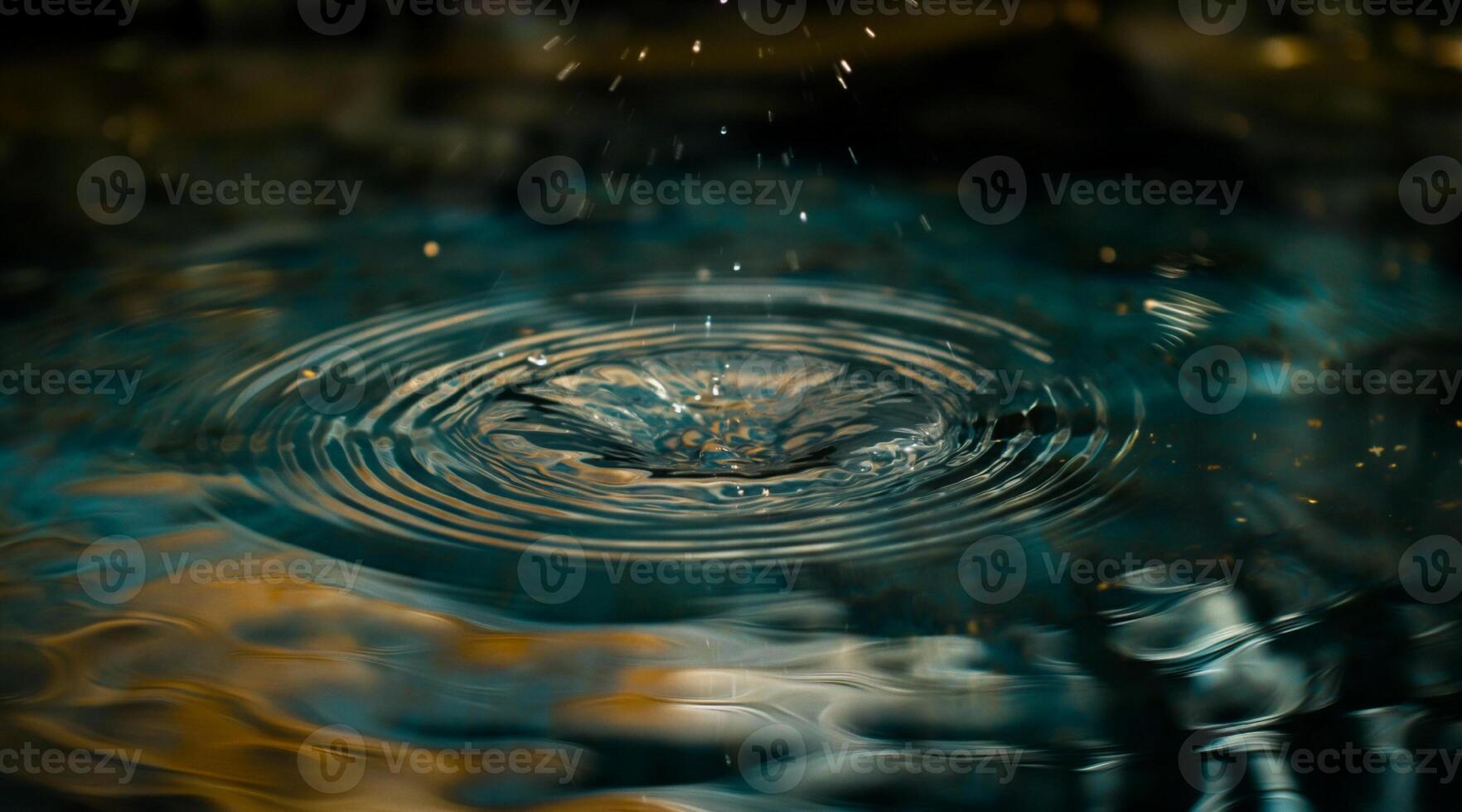 A drop of water is falling into a pool photo
