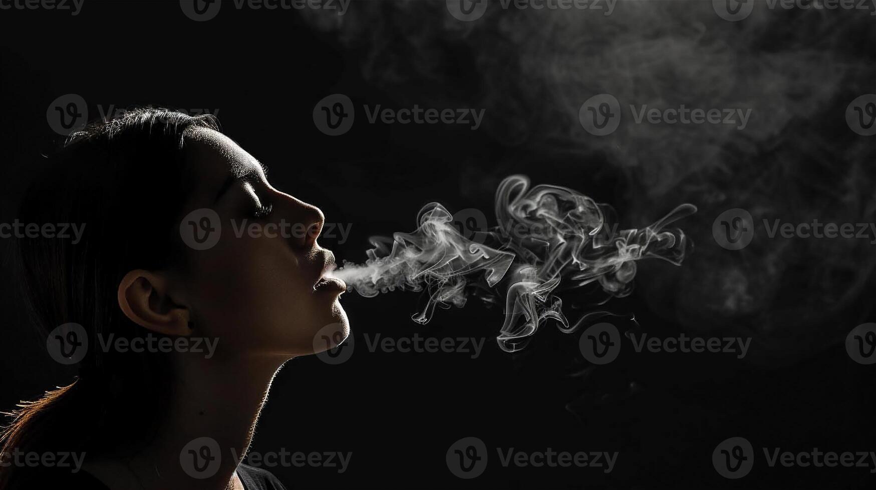 Girl releases cigarette smoke on a black background, close-up photo