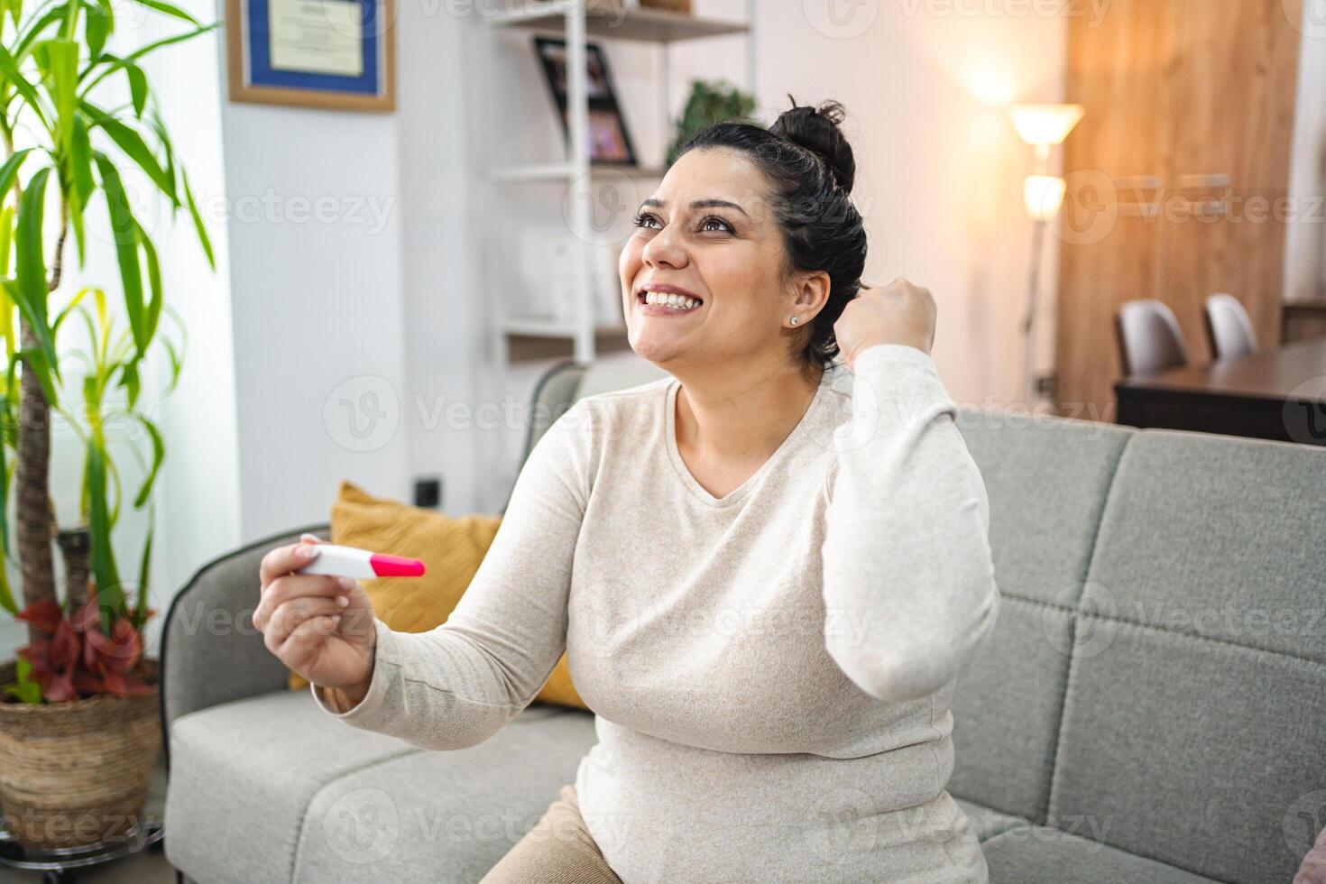 Woman feeling excited after doing a pregnancy test photo