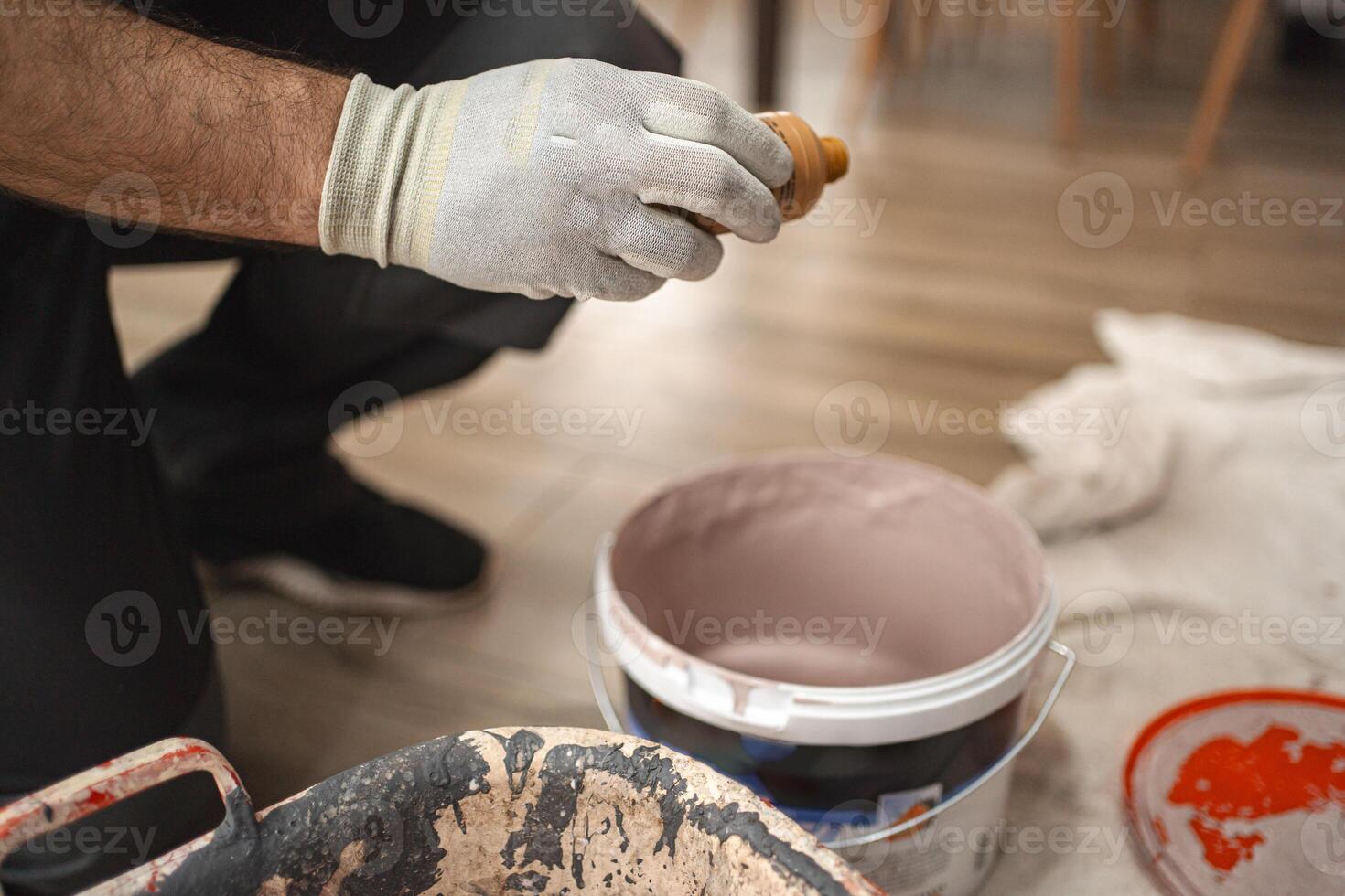 Man prepares paint for painting a wall photo