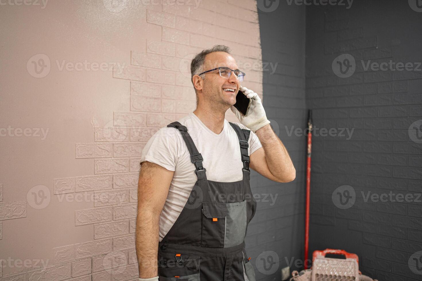Man in Overalls Talking on Cell Phone photo