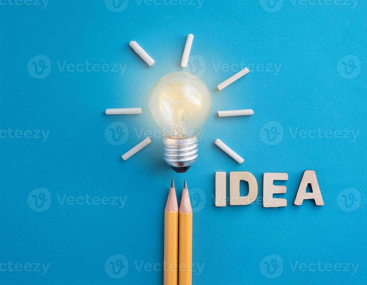 Creativity Concept with Light Bulb, Pencil, and 'Idea' Text on Blue photo