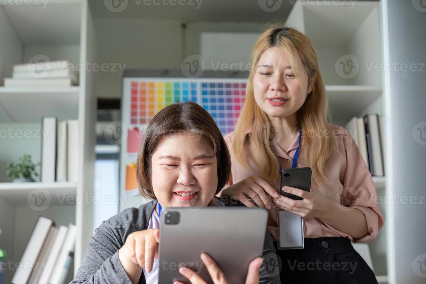 Diverse graphic design team collaborating on a tablet in a creative workspace. photo