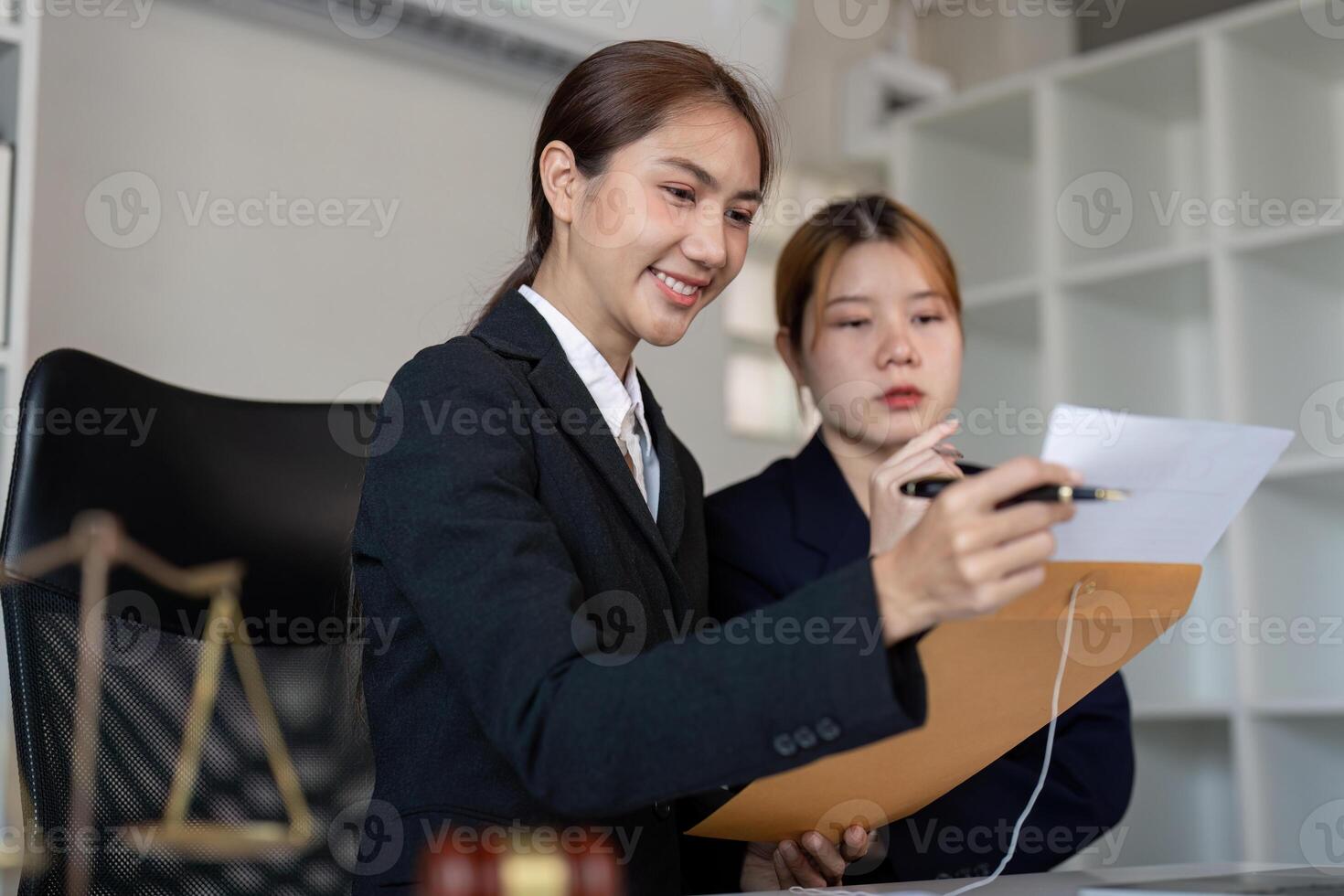 Lawyer explaining legal documents to a client in an office with a gavel on the desk. photo