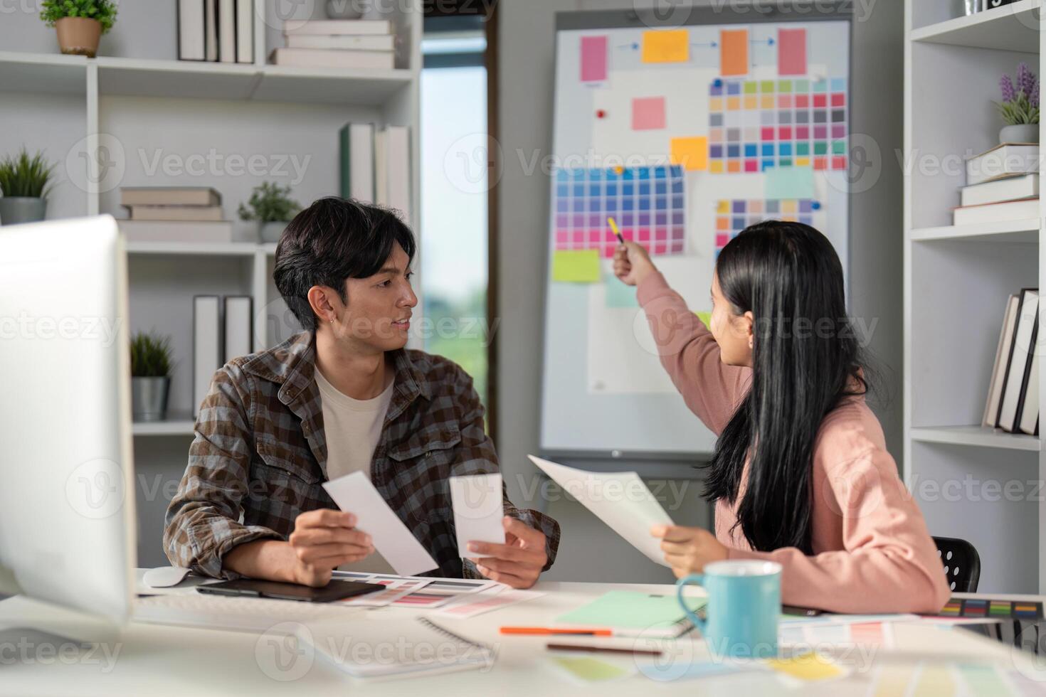Diverse graphic design team discussing color selections and project concepts in a vibrant workspace. photo